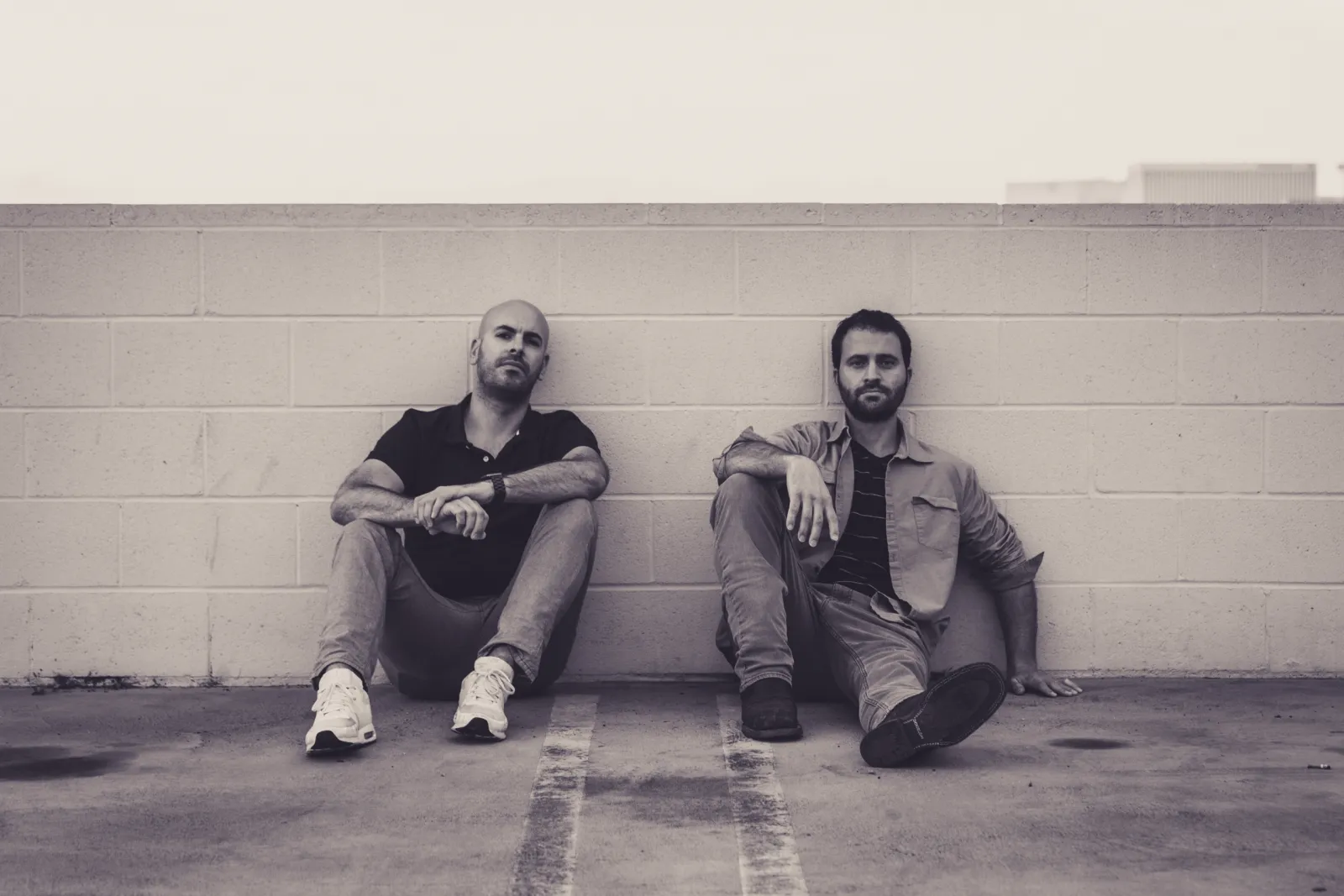Daniel Bukowski and Weston Ripps sitting against a wall